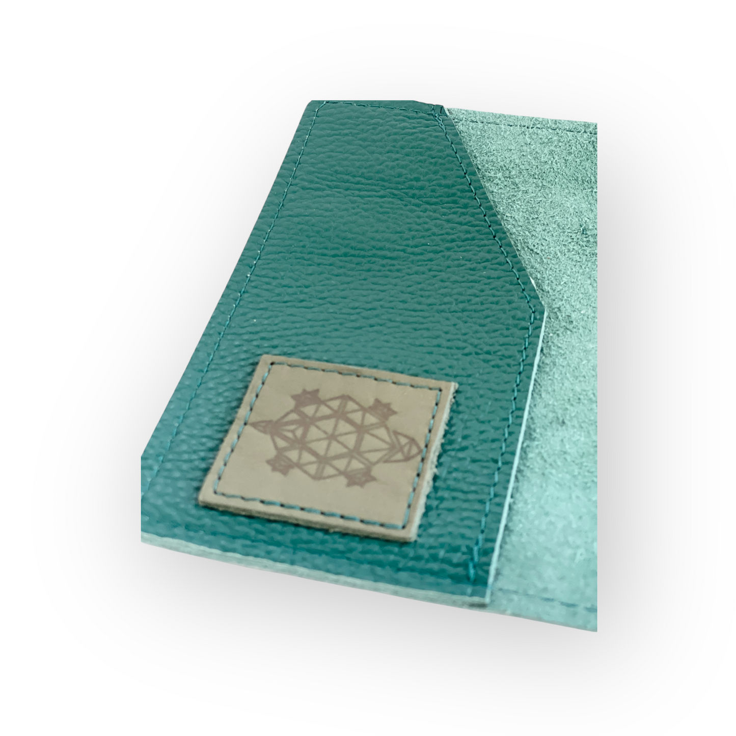 Green leather passport holder with a leather patch on the inside featuring a geometric design ed turtle on a white backgroundolder